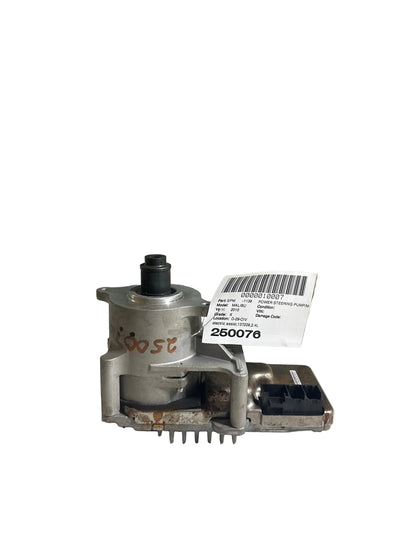 Mechanical part with a label on a surface, with a scenic background of trees and buildings.